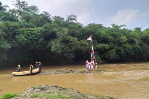 Pengibaran Bendera Merah Putih di Tengah Sungai Ciliwung