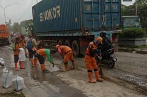 Cegah Kecelakaan, Petugas Bersihkan Ceceran Pasir dan Tanah di Jalan Akses Marunda