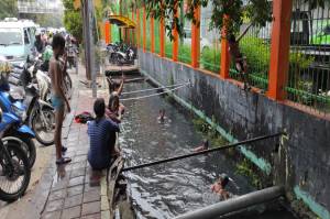 Satpol PP Pelototi Anak Berenang di Selokan Hitam Kampung Bandan Jakut
